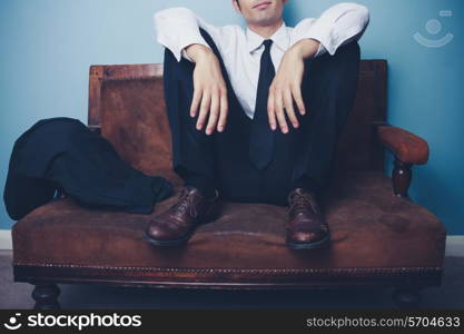 Young businessman sitting on old sofa