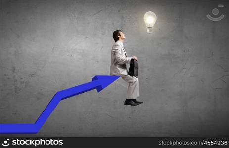 Young businessman sitting on top of growing graph. On top of success