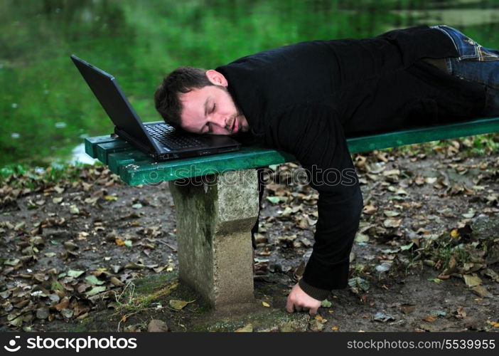 young businessman sleeping with head on laptop