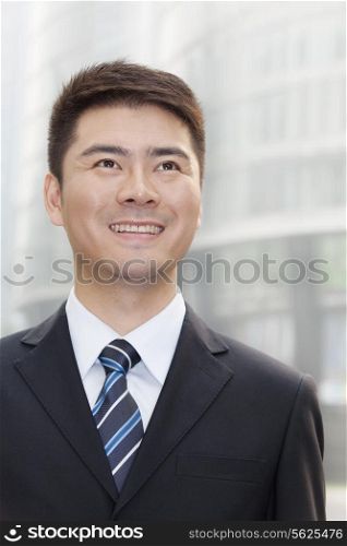 Young Businessman Smiling and Looking Up, Portrait