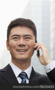 Young Businessman Smiling and Talking on Smart Phone