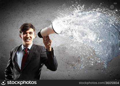 young businessman smiling in black suit holding megaphone