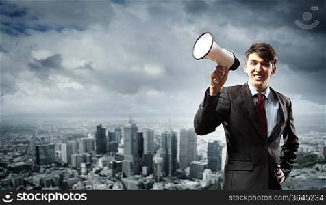 young businessman smiling in black suit holding megaphone