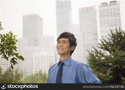 Young businessman smiling in the park, portrait