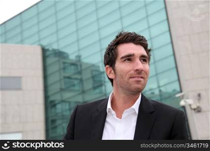 Young businessman standing in front of buildings