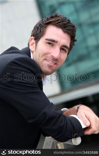 Young businessman standing in front of buildings
