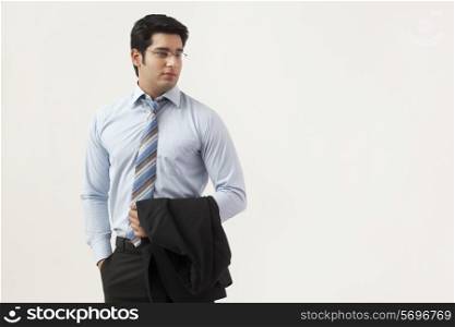 Young businessman standing over colored background