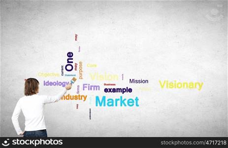 Young businessman standing with back and writing different words on wall. Copyright concept