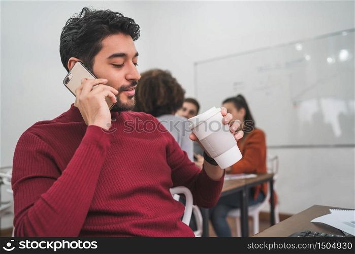 Young businessman talking on the phone and working at his workplace. Business concept.