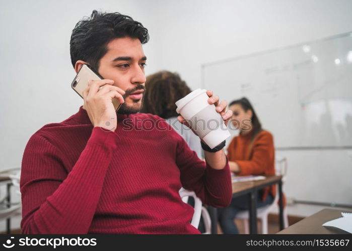 Young businessman talking on the phone and working at his workplace. Business concept.