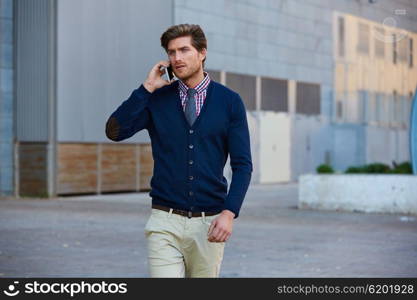 Young businessman talking smartphone phone walking on the street