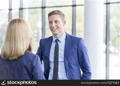 Young businessman talking with businesswoman in office during meeting