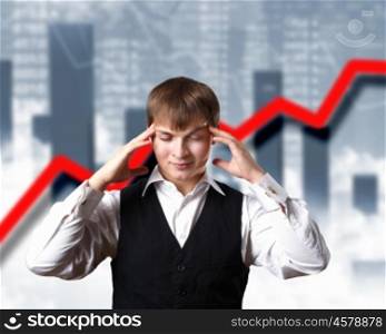 Young businessman thinking and analyzing financial graphs