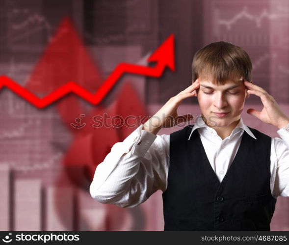 Young businessman thinking and analyzing financial graphs