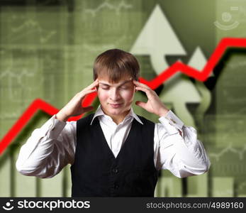 Young businessman thinking and analyzing financial graphs