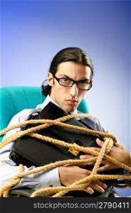 Young businessman tied with rope
