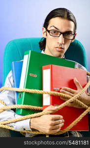 Young businessman tied with rope