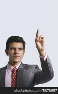 Young businessman touching visual screen against white background
