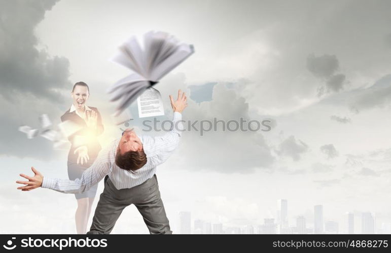 Young businessman trying to evade from thrown book