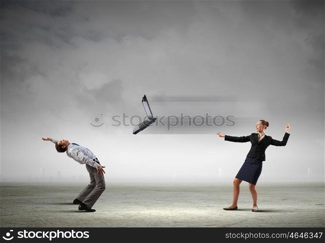 Young businessman trying to evade from thrown laptop. Two business people fighting with each other
