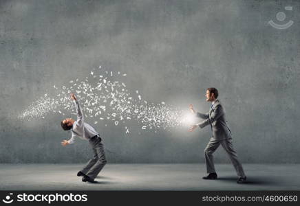 Young businessman trying to evade from thrown paper documents. Two business people fighting with each other