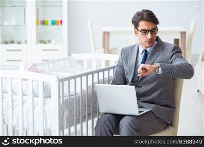 Young businessman trying to work from home caring after newborn baby