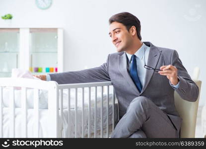 Young businessman trying to work from home caring after newborn baby