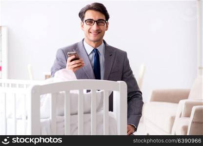 Young businessman trying to work from home caring after newborn baby. Young businessman trying to work from home caring after newborn