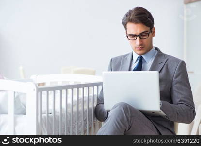 Young businessman trying to work from home caring after newborn baby