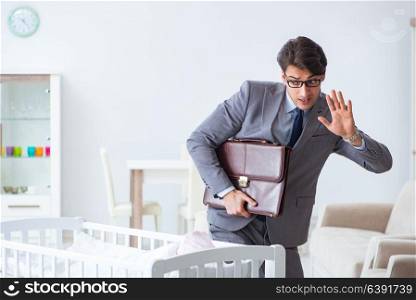 Young businessman trying to work from home caring after newborn baby. Young businessman trying to work from home caring after newborn