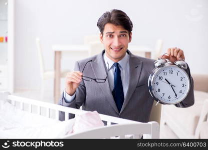 Young businessman trying to work from home caring after newborn baby. Young businessman trying to work from home caring after newborn