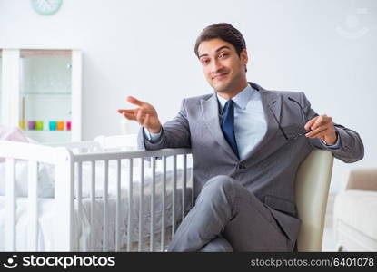 Young businessman trying to work from home caring after newborn baby