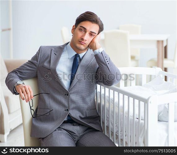 Young businessman trying to work from home caring after newborn baby. The young businessman trying to work from home caring after newb