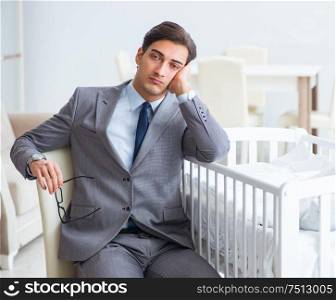 Young businessman trying to work from home caring after newborn baby. The young businessman trying to work from home caring after newb