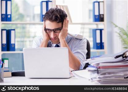 Young businessman under pressure in office to deliver tasks. The young businessman under pressure in office to deliver tasks
