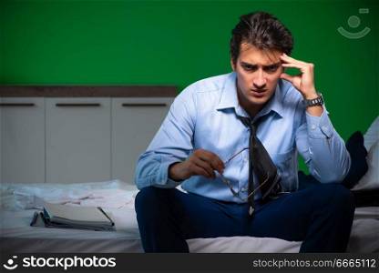 Young businessman under stress in the bedroom at night . Young businessman under stress in the bedroom at night