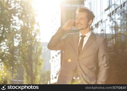 Young businessman using cell phone outdoors
