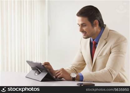 Young businessman using digital tablet at office desk