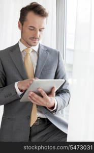 Young businessman using digital tablet in office