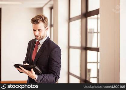 Young businessman using digital tablet touchscreen in office