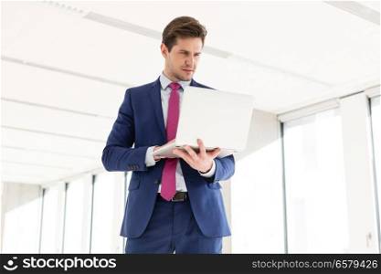 Young businessman using laptop in new office