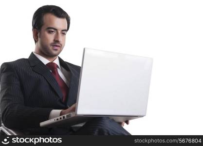 Young businessman using laptop over white background