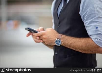 Young Businessman Using Mobile Phone While Standing In City