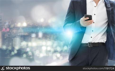 Young businessman using mobile phone with modern city buildings background. Future telecommunication technology and internet of things ( IOT ) concept.. Internet of things - Telecommunication Technology