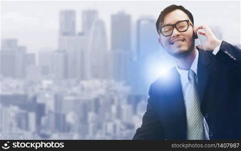 Young businessman using mobile phone with modern city buildings background.. Man using mobile phone with modern city background