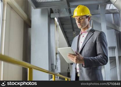 Young businessman using tablet computer in industry