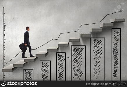 Young businessman walking up on staircase representing success concept. Up the career ladder