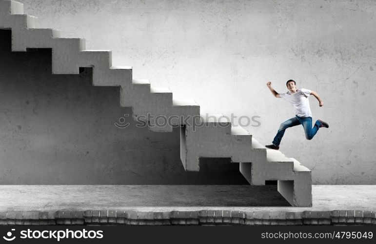 Young businessman walking up on staircase representing success concept. Up the career ladder