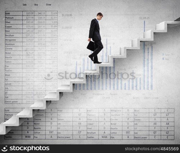 Young businessman walking up on staircase representing success concept. Up the career ladder