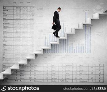 Young businessman walking up on staircase representing success concept. Up the career ladder